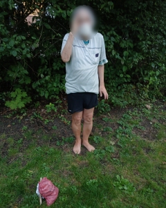 Stiller Helfer klaubt Kronkorken und Zigarettenkippen aus Wiese
